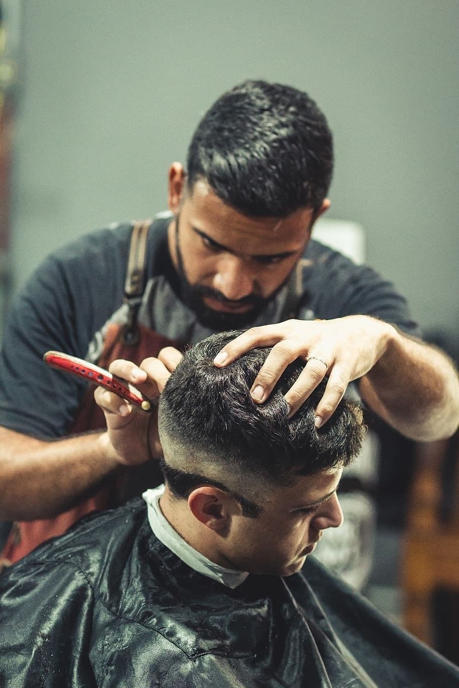 Barbero emparejando un corte con peine y tijera